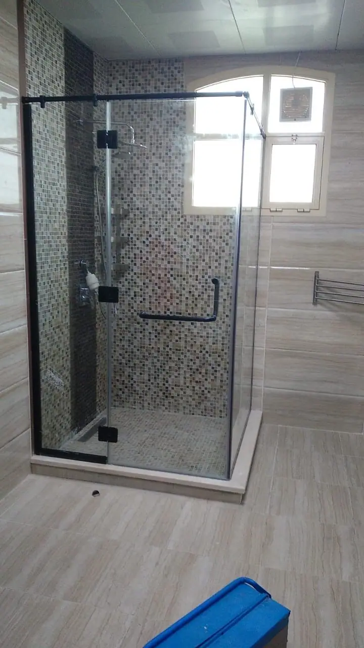 كابينة استحمام زاوية بإطار أسود مع بلاط موزاييك